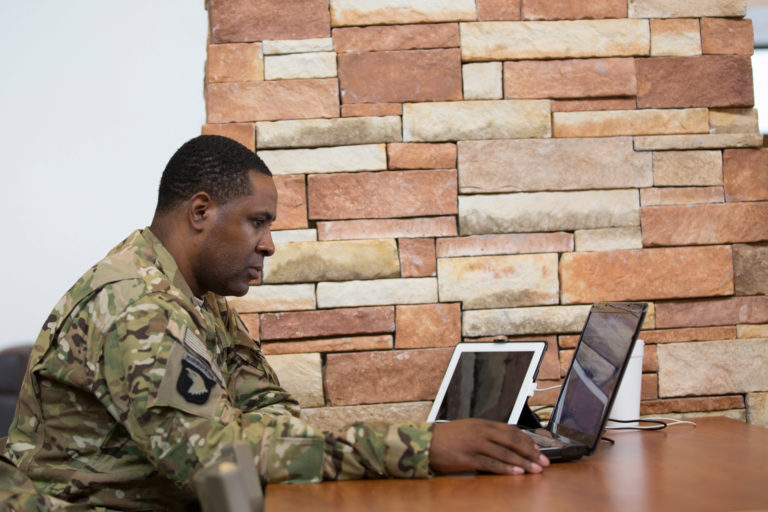 student in uniform at laptop