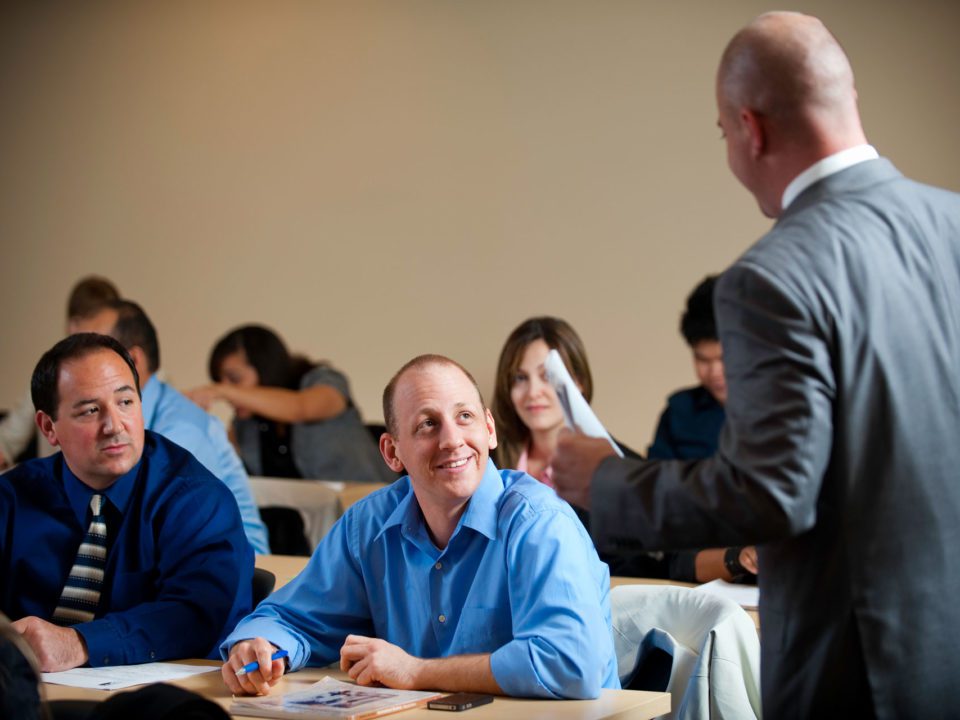 students in class talking with instructor, business administration