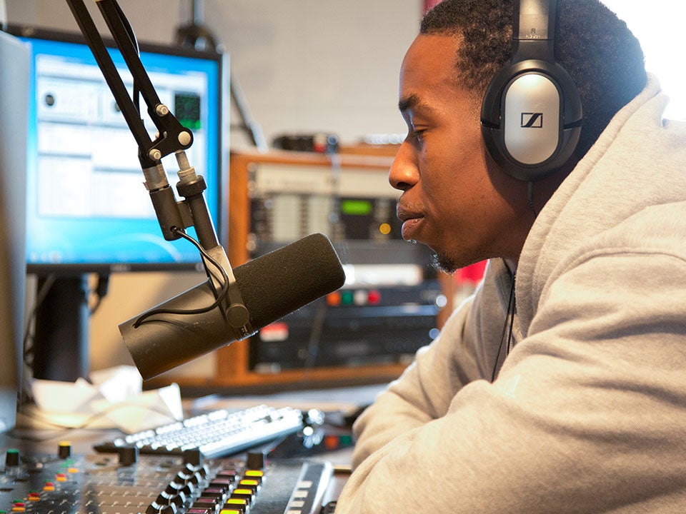 student with headphones at mic