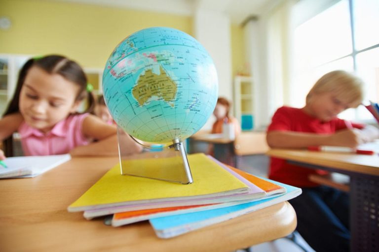 globe on desk with school children
