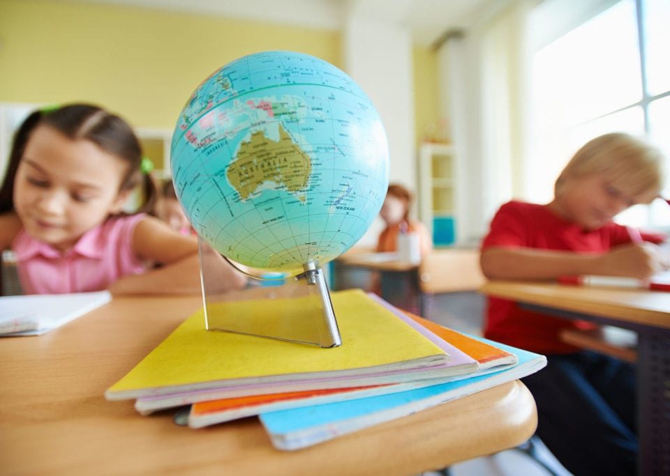 globe on desk with school children