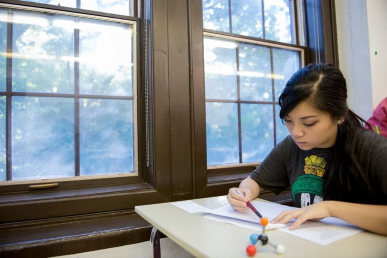 student at desk by window