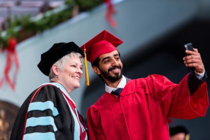 instructor and graduate in cap and gowns