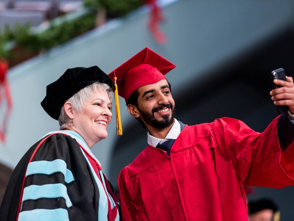 instructor and graduate in cap and gowns