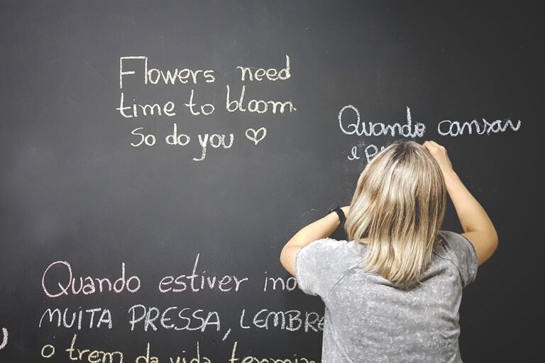 student writing on blackboard