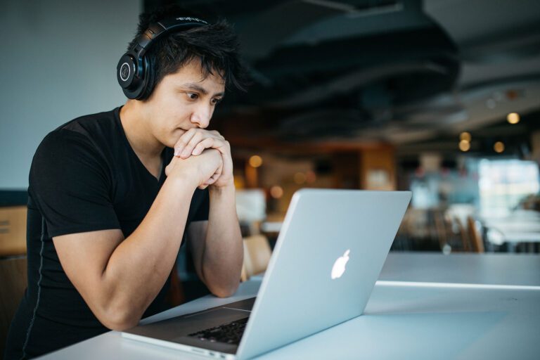 student with earphones on laptop