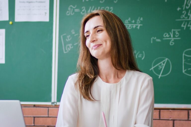 teacher in front of black board
